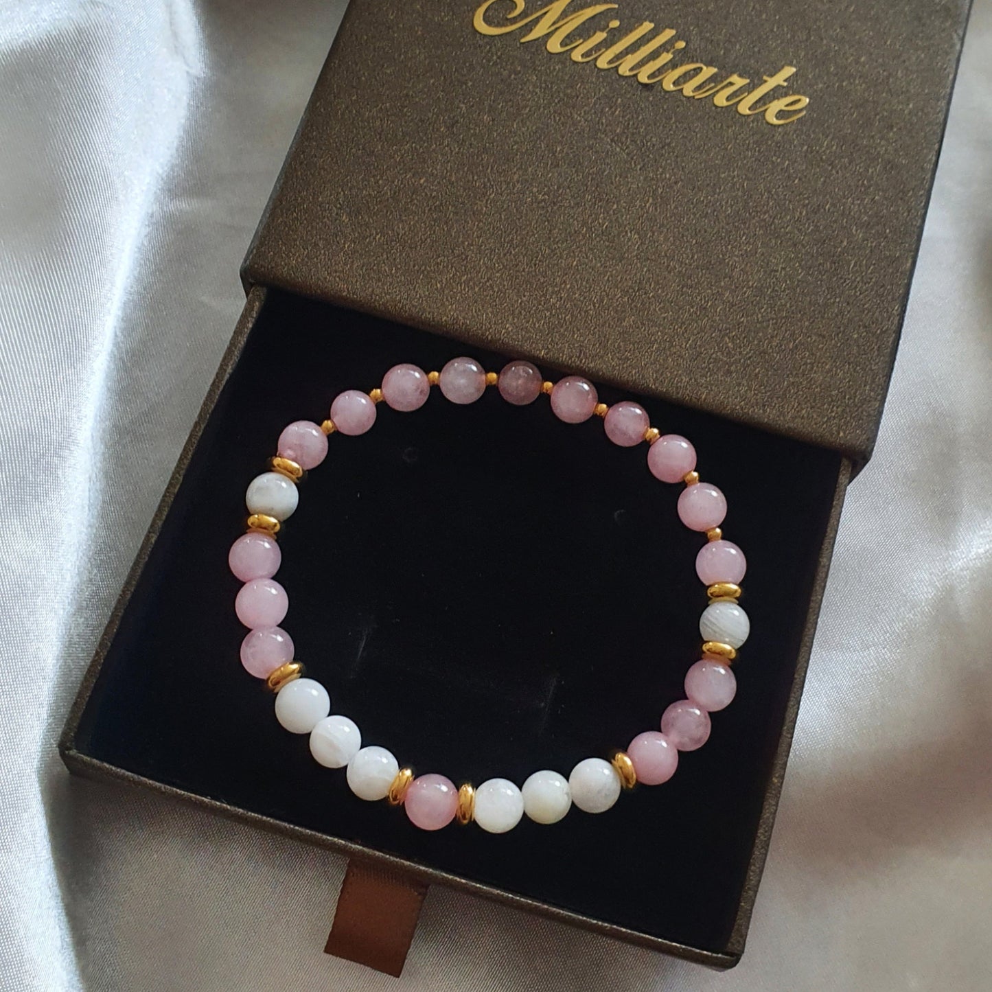 Feines Perlenarmband mit Goldveredelung, stilvoll auf Logo-Box