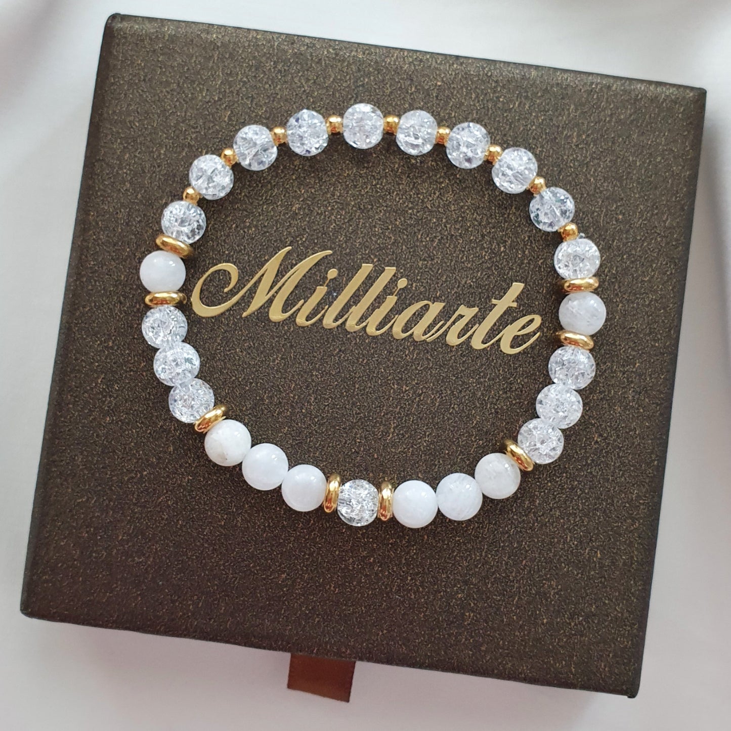 Mondstein Bergkristall Armband mit Goldelementen nah fotografiert auf Schmuckbox