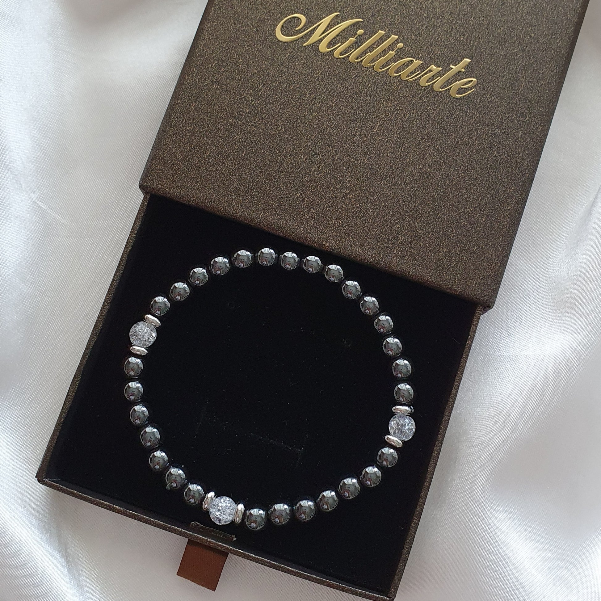 Detailansicht: Glänzende Hämatit-Perlen mit funkelndem Bergkristall 