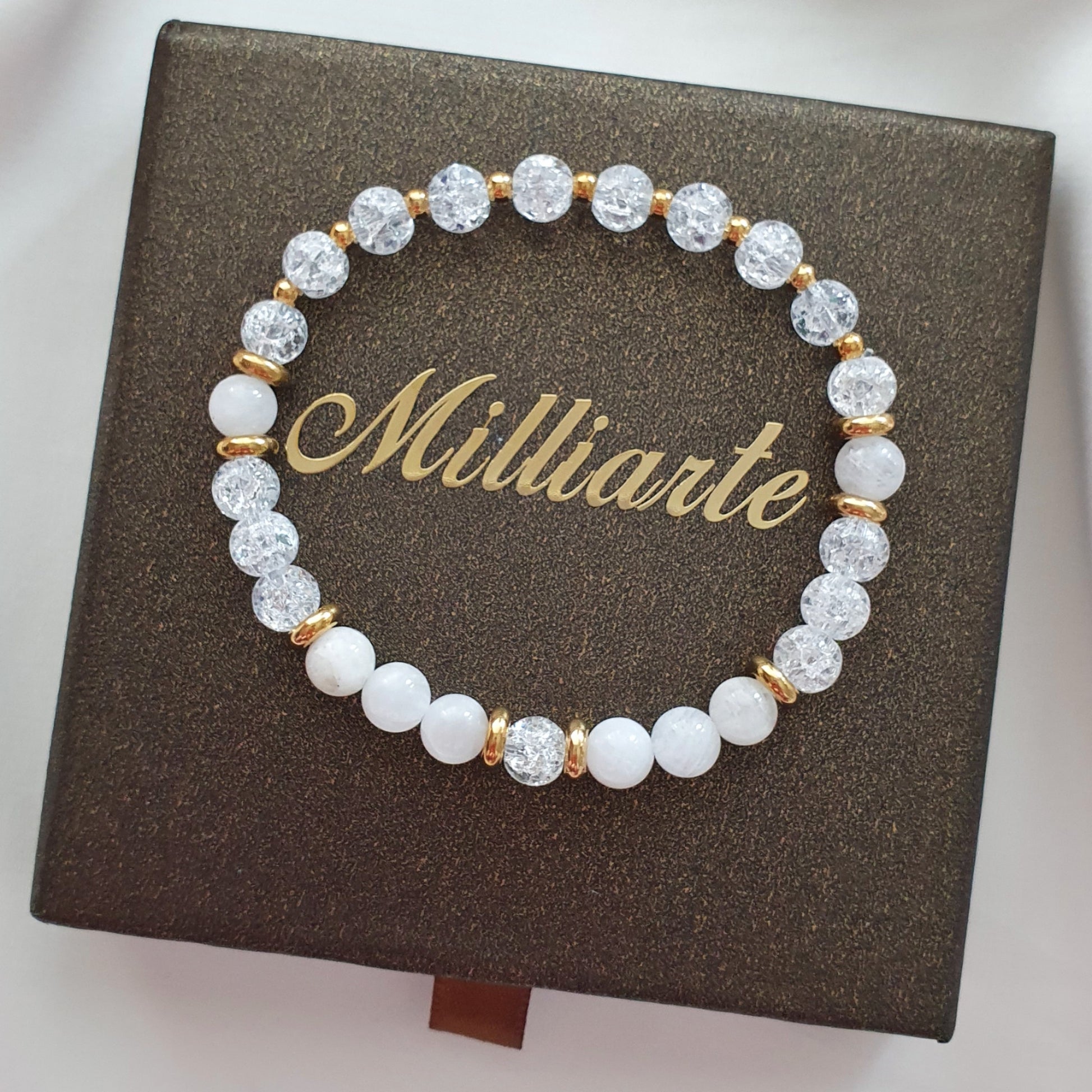 Mondstein Bergkristall Armband mit Goldelementen nah fotografiert auf Schmuckbox